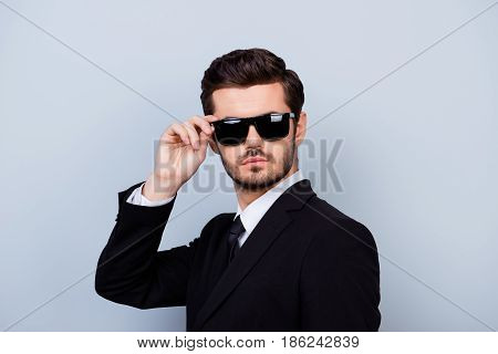 Portrait Of Handsome Young Serious Man In Black Siut And Glasses Trying  To Remain Anonymous