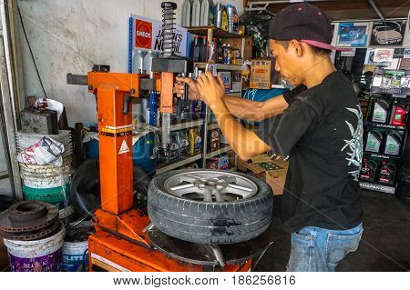 Labuan,Malaysia-May 9,2017:Car tire service mechanic changing car wheel before makes computer wheel balancing on special equipment machine tool in auto repair service in Labuan,Malaysia.
