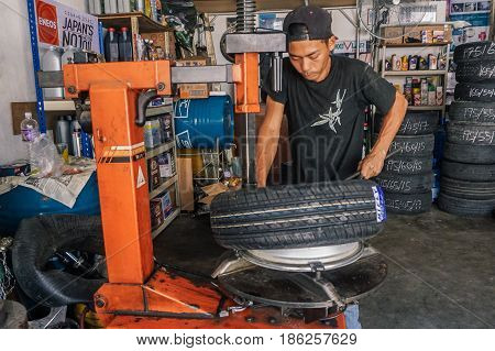 Labuan,Malaysia-May 9,2017:Car tire service mechanic changing car wheel before makes computer wheel balancing on special equipment machine tool in auto repair service in Labuan,Malaysia.