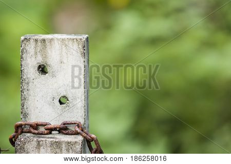 Rusty chains that tie on cement pillars.