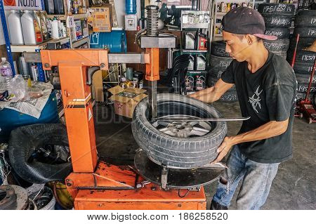 Labuan,Malaysia-May 9,2017:Car tire service mechanic changing car wheel before makes computer wheel balancing on special equipment machine tool in auto repair service in Labuan,Malaysia.