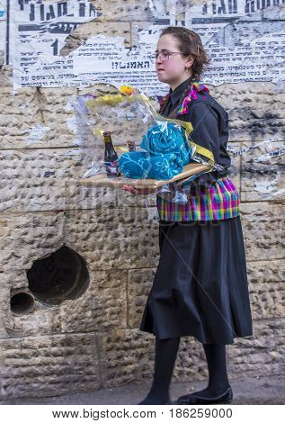 JERUSALEM - MARCH 13 : Ultra Orthodox woman holding Mishloach Manot during Purim in Mea Shearim Jerusalem on March 13 2017 Mishloach Manot is traditional food gifts given during Purim
