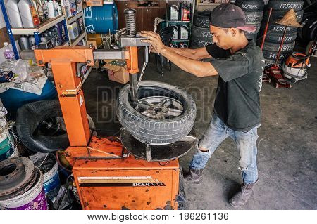 Labuan,Malaysia-May 9,2017:Car tire service mechanic changing car wheel before makes computer wheel balancing on special equipment machine tool in auto repair service in Labuan,Malaysia.