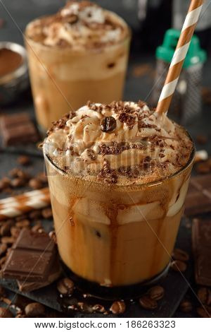 Cold frappe coffee with cream on a gray background