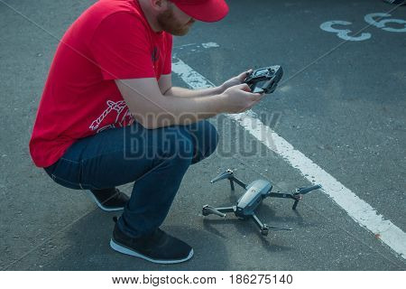 The guy starts a quadrocopter with an asphalt surface. Preparation for start, calibration of navigation systems