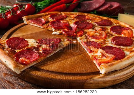 Junk food, bad habits. Pizza sliced on rustic wooden table background. Italian traditional meal, unhealthy eating, dining concept