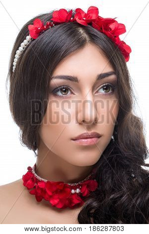 Beautiful brunette young woman with red ribbon headband and bracelets. Beauty shot on white background. Isolated. Copy space.
