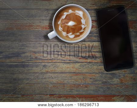 Black Cell phone and art cappuccino. top view with copy space