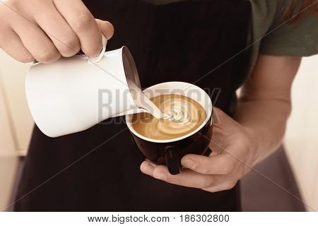 Man drawing on coffee with frothed milk
