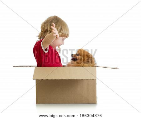 Smiling child boy and dog playing in cardbox isolated on white background