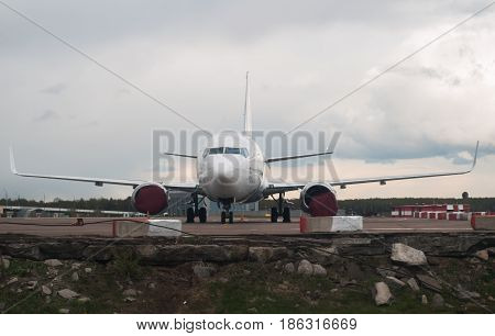 The Plane On The Background Of The Cloudy Sky And Forest,