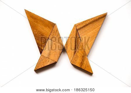Wooden tangram puzzle in butterfly shape on white background