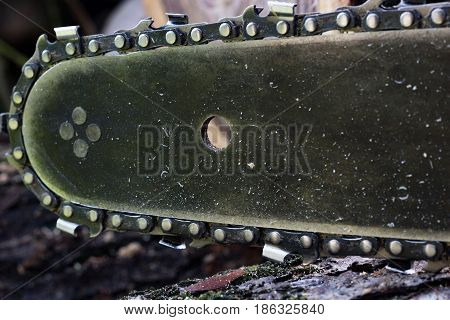 Close up chainsaw and teeth set on a chain around the edge.