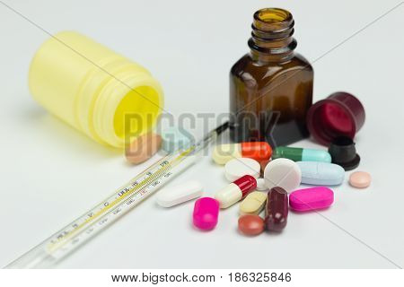 Colorful antibiotic, Medicine pills or capsules and thermometer on white background.