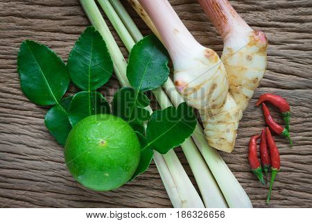 Tom yam ingredient lemon lemongrass galangal and chili on wood table for thai spicy soup.