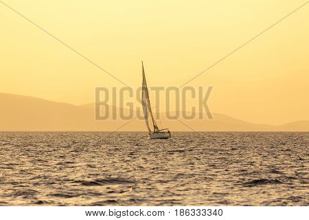 Sailboat in Greece at sunset light. Sundow