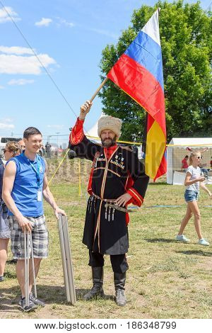 BERLIN - JUNE 11 2016: Russian Cossack with the Russian flag. German-Russian festival devoted to the Independence Day of Russia. District Karlshorst East Berlin.