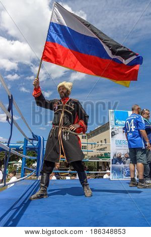 BERLIN - JUNE 11 2016: Russian Cossack with the Russian flag. German-Russian festival devoted to the Independence Day of Russia. District Karlshorst East Berlin.