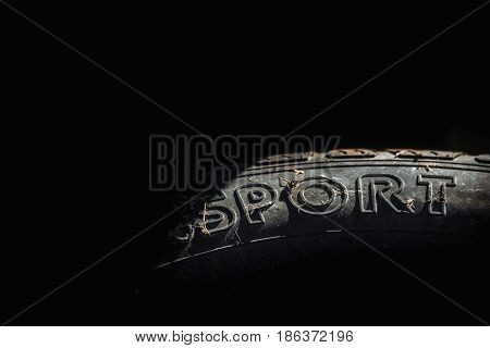 Close up used car tyre with word sport written on it