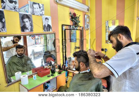 Bandar Abbas Hormozgan Province Iran - 16 april 2017: Iranian Barber salon Persian hairdresser makes the hair style for man.