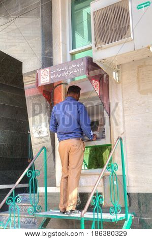 Bandar Abbas Hormozgan Province Iran - 16 april 2017: One man uses a street ATM to withdraw cash.