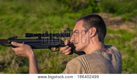 The man takes aim at the target with a retro sniperl rifle. Selective Focus