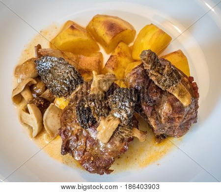 Roasted Pork With Mushrooms And Potatoes On White Plate