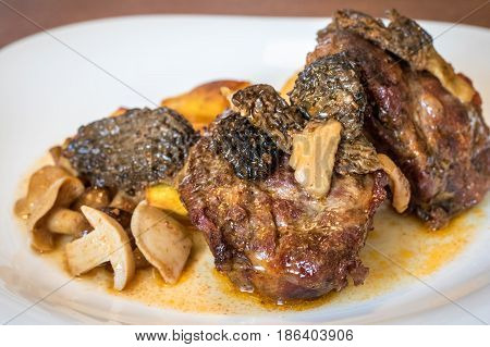 Close Up Shot Of Plate With Baked Pork And Mushrooms