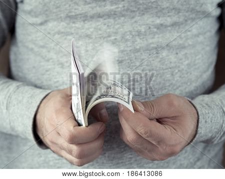 Hands counting dollars. Selective focus. Shallow DOF