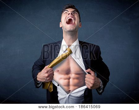 Businessman tearing off his shirt and showing mucular body concept on background