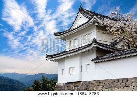 Kyoto, Japan - April 2, 2016 - One of the white guard towers of Kyoto's historic Nijo Castle stands in stark contrast to a blue spring sky.
