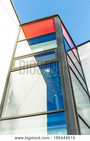 Red and white rendered modern building facade on a bright sunny day with clear sky. Abstract background.