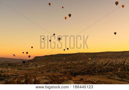 Hot air balloons flying over valley of Cappadocia at sunrise. Nevsehir Province. Turkey