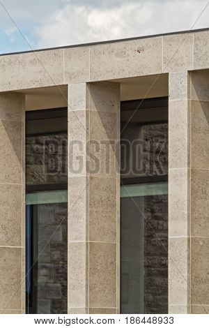 Building facade with elegant Birttish Portland Stone columns. The windows of the building reflecting the stones