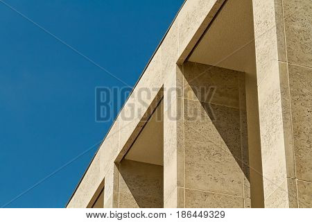 Building facade with elegant Birttish Portland Stone columns. Sunny day with blue clear sky.