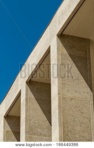 Building facade with elegant Birttish Portland Stone columns. Sunny day with blue clear sky.