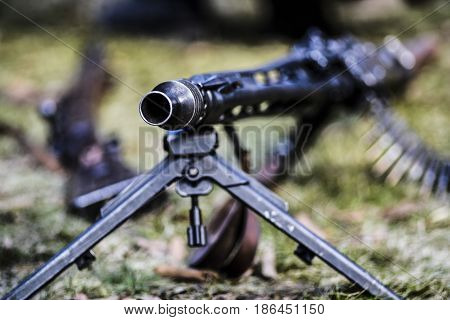 A rifle of machine gun with ammunition outdoor.