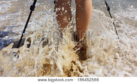 Legs of a person and tripod's legs in the sea. 
With crashing waves and well-defined and detailed drops.