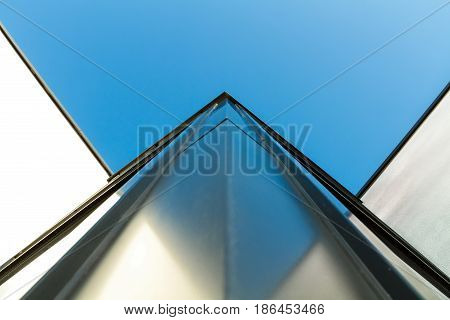 Corner detail of a modern building facade on a bright sunny day with clear sky. Abstract background. Space for text