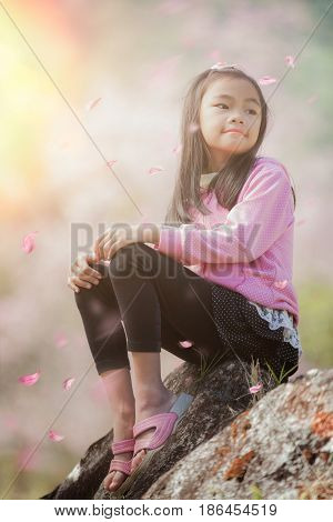 Asian girl sit and relax with Sakura fall in Japan