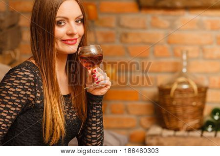Woman Tasting Wine In Rural Cottage Interior