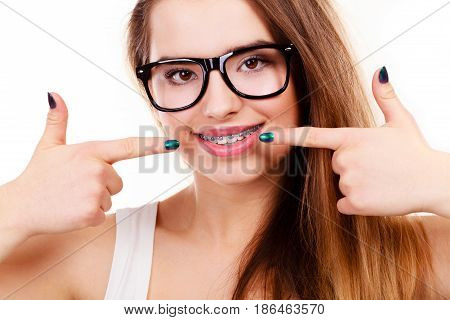 Dentist and orthodontist concept. Nerdy geek woman wearing big eyeglasses smiling showing her white teeth with blue braces