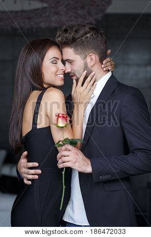 Young rich couple with rose dating indoor