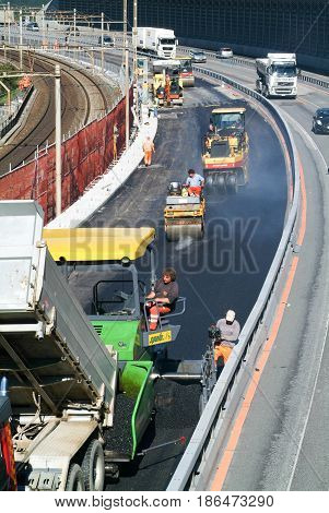 Workers And Vehicles During The Asphalting Of The Highway