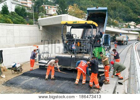 Workers And Vehicles During The Asphalting Of The Highway