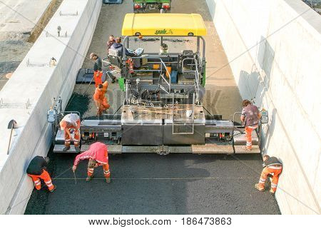 Workers And Vehicles During The Asphalting Of The Highway