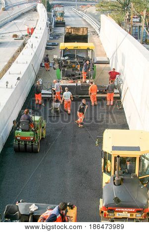 Workers And Vehicles During The Asphalting Of The Highway