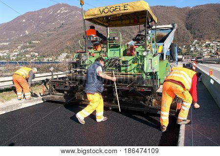 Workers And Vehicles During The Asphalting Of The Highway