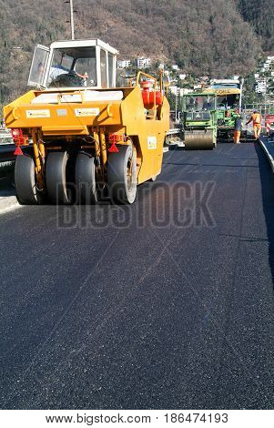 Workers And Vehicles During The Asphalting Of The Highway