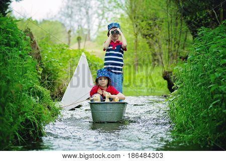 Cute Children, Boys, Playing With Boat And Ducks On A Little Rive